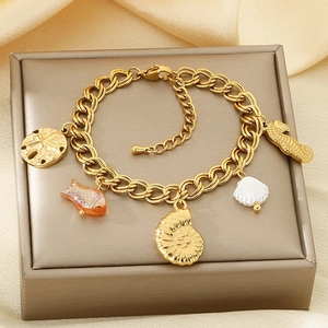 Macro shot of gold ocean charms with seahorse and starfish on silk jewelry display