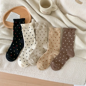 Elegant polka dot wool socks for women in five warm colors displayed on cozy fleece background