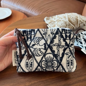 Detail of handmade linen coin purse with embroidery and simple wish woven label