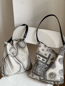 Detail of patterned tote bags with leather straps featuring geometric and paisley prints