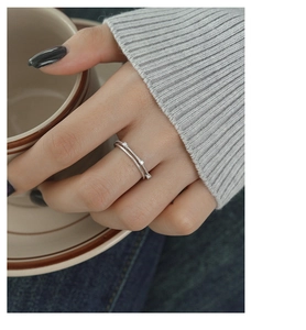 Detail of minimalist double-layer silver ring with zircons on a model's hand