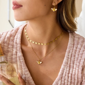 Set collana con ape dorata e choker farfalla su modella in stile casual moderno