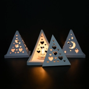 Set of four white pyramid candle holders with moon and heart cutouts for home decor