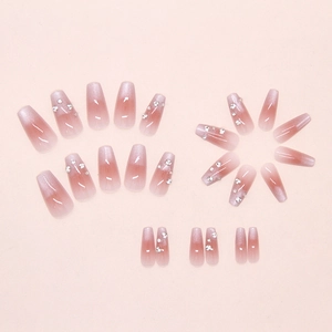 Macro view of pink gradient cat-eye press-on nails with delicate rhinestone accents