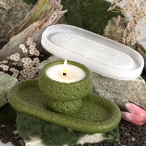 Detail of green stone-textured candle cup and oval tray set with natural moss background
