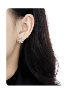 Detail of S925 sterling silver wreath earrings with sparkling zircons on model ear