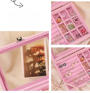Detailed view of pink velvet jewelry box showing multiple compartments and transparent lid