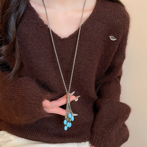 Detail of bohemian long necklace with turquoise water-drop beads and metal tassels
