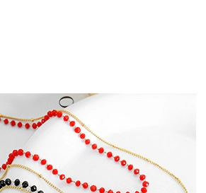 Detail of red faceted beads on a delicate 18K gold plated snake chain anklet