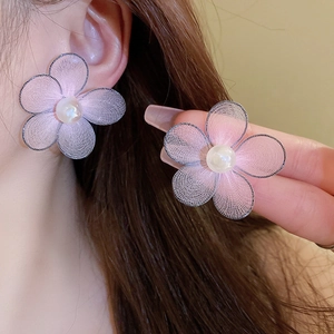 Detailed macro view of pink mesh petal earrings with a round white pearl center