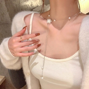 Vue détaillée du collier perle en Y doré élégant et de la bague assortie sur le modèle