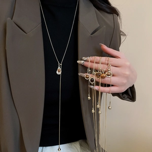 Close-up of golden vintage necklaces with brown tiger eye stone heart and geometric pendants