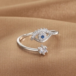 Silver adjustable evil eye open ring with blue stone and star on gold satin background