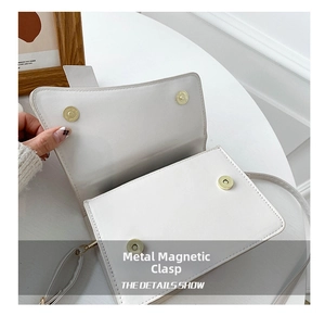 Close-up of white PU leather crossbody bag featuring four golden magnetic snap closures