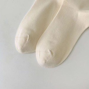 Dettaglio ravvicinato di calze in cotone beige con punta senza cuciture e trama morbida