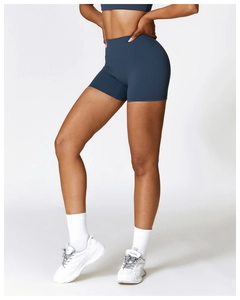 Dettaglio degli shorts da yoga blu scuro a vita alta che mostrano la vestibilità sul modello