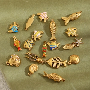 Detailed macro of gold octopus and fish pendants with colorful enamel and pearls