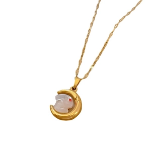 Minimalist gold moon and shell bunny necklace with red eye on white background
