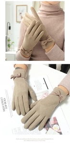 Close-up of beige faux suede gloves with bow detail and touch screen function