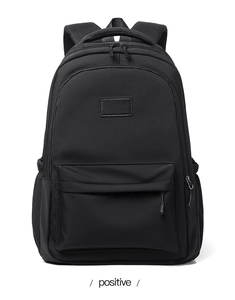 Detailed front view of black minimalist nylon backpack with large capacity and side pockets
