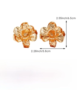 Detail view of large gold floral earrings with hammered texture and 6.5cm size markings