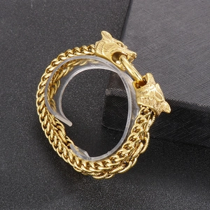 Detailed close-up of golden wolf head carving on a textured double-layer men's bracelet