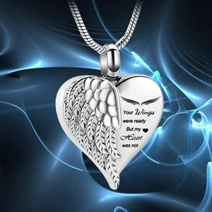 Close-up of silver heart cremation pendant with angel wing and memorial engraving