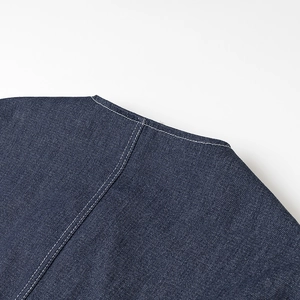 Gros plan détaillé du denim bleu foncé avec des coutures contrastées blanches à double aiguille