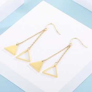 Close-up of golden geometric earrings with hollow and solid triangle tassels
