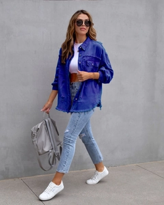 Outdoor-Aufnahme einer übergroßen Jeansjacke mit offenen Kanten und Distressed-Details
