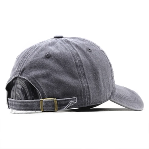 Detail view of washed canvas baseball cap featuring a bronze adjustable metal buckle
