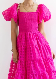 Detail of smocked bodice and puff sleeves on fuchsia checkered off-shoulder dress