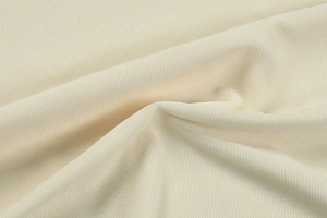 Close-up of premium cream knitted fabric detail with fine mesh texture and soft drape