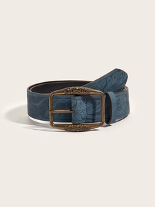Close-up of vintage indigo leather belt with embossed floral patterns and bronze buckle