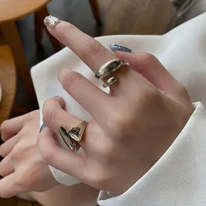 Detail of silver irregular liquid metal rings with adjustable open organic design