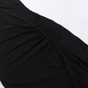 Vue détaillée du tissu noir avec d'élégants froncements et drapés sur l'épaule