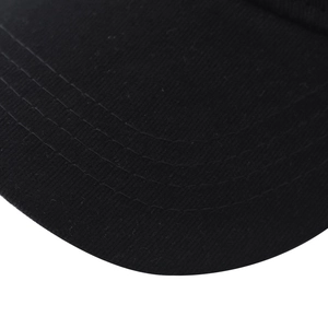 Close-up of a black cotton baseball cap brim with parallel reinforced stitching detail