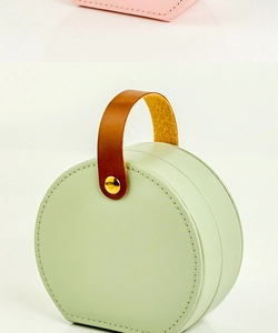 Detail of light green PU leather jewelry box with brown handle and golden metal rivet