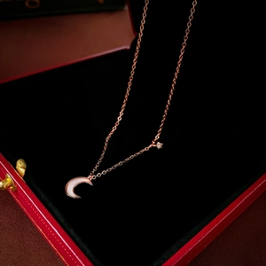 Élégant collier ras du cou lune et étoile en or rose dans un coffret à bijoux rouge chic