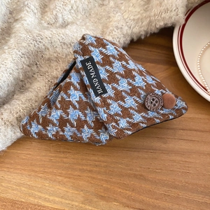 Detail of acrylic hair claw with blue plaid fabric, retro button and small pompom