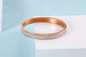 Détails du bracelet jonc or rose avec des rangées denses de cristaux scintillants