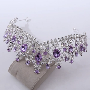Detailed close-up of a silver bridal crown with purple teardrop crystals and clear rhinestones