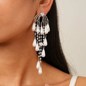 Detail of silver drop earrings with white pearls and sparkling zircon on a model