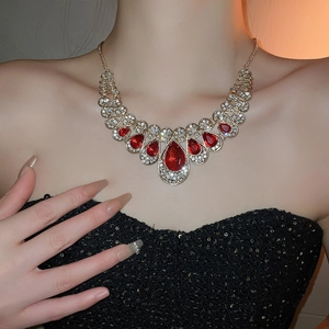 Detail of vintage necklace set with red water drop gems and rhinestones on model neck