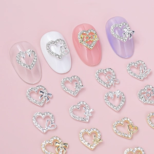 Bowtie heart nail art charms set with silver and gold alloy rhinestones on pink background