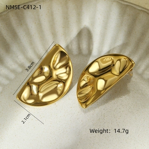 Hammered gold textured stainless steel hoop earrings in a minimalist jewelry display