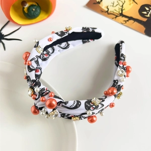 Detail of Halloween knotted headband with black skull print and colorful pearls