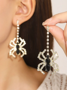 Close-up of gothic spider pendant earrings with gold finish and sparkling black rhinestones