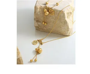 Detailed view of golden gourd pendant necklace with Fu character charm on natural stone