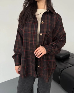 Detail view of the button-down placket and collar on a plaid long-sleeve shirt